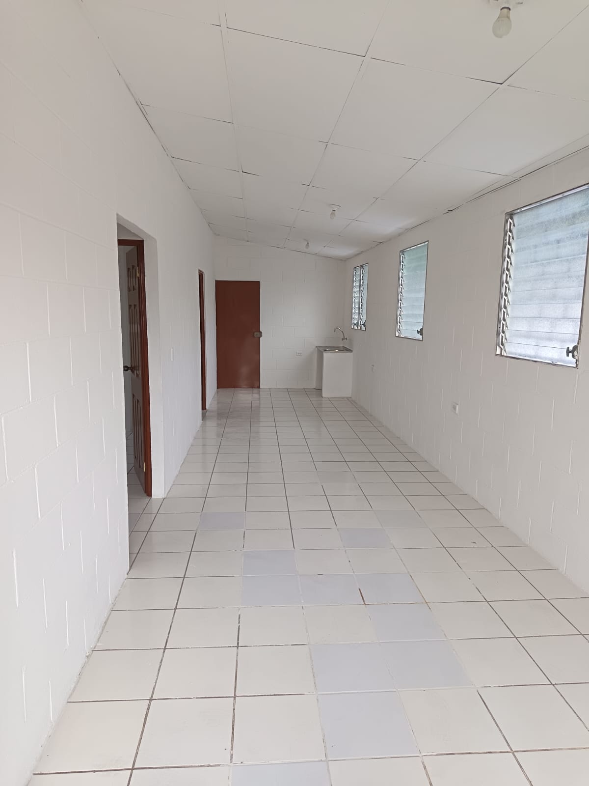 Sala tipo pasillo con piso ceramico blanco