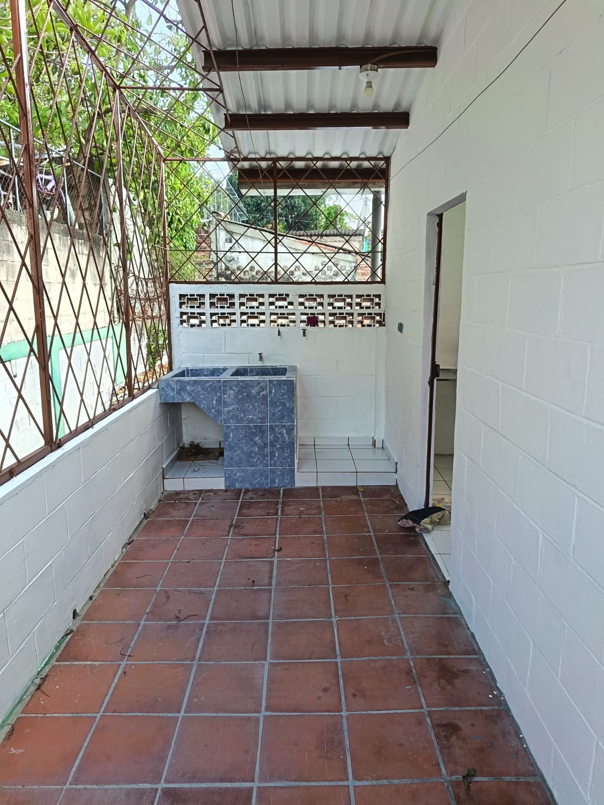 Patio trasero con lavadero y totalmente cerrado con rejilla