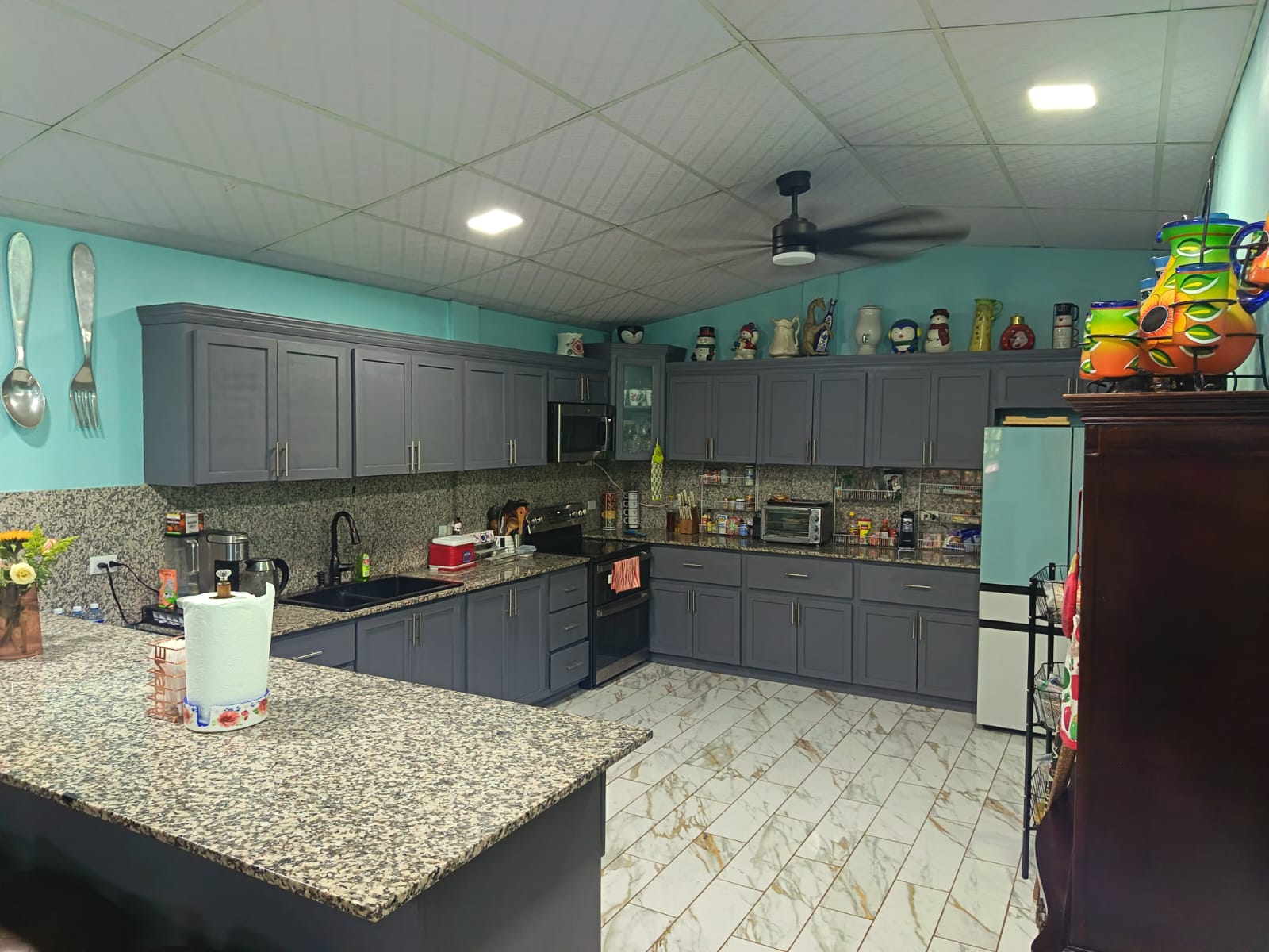 Cocina con pantry de madera y desayunador con top de granito