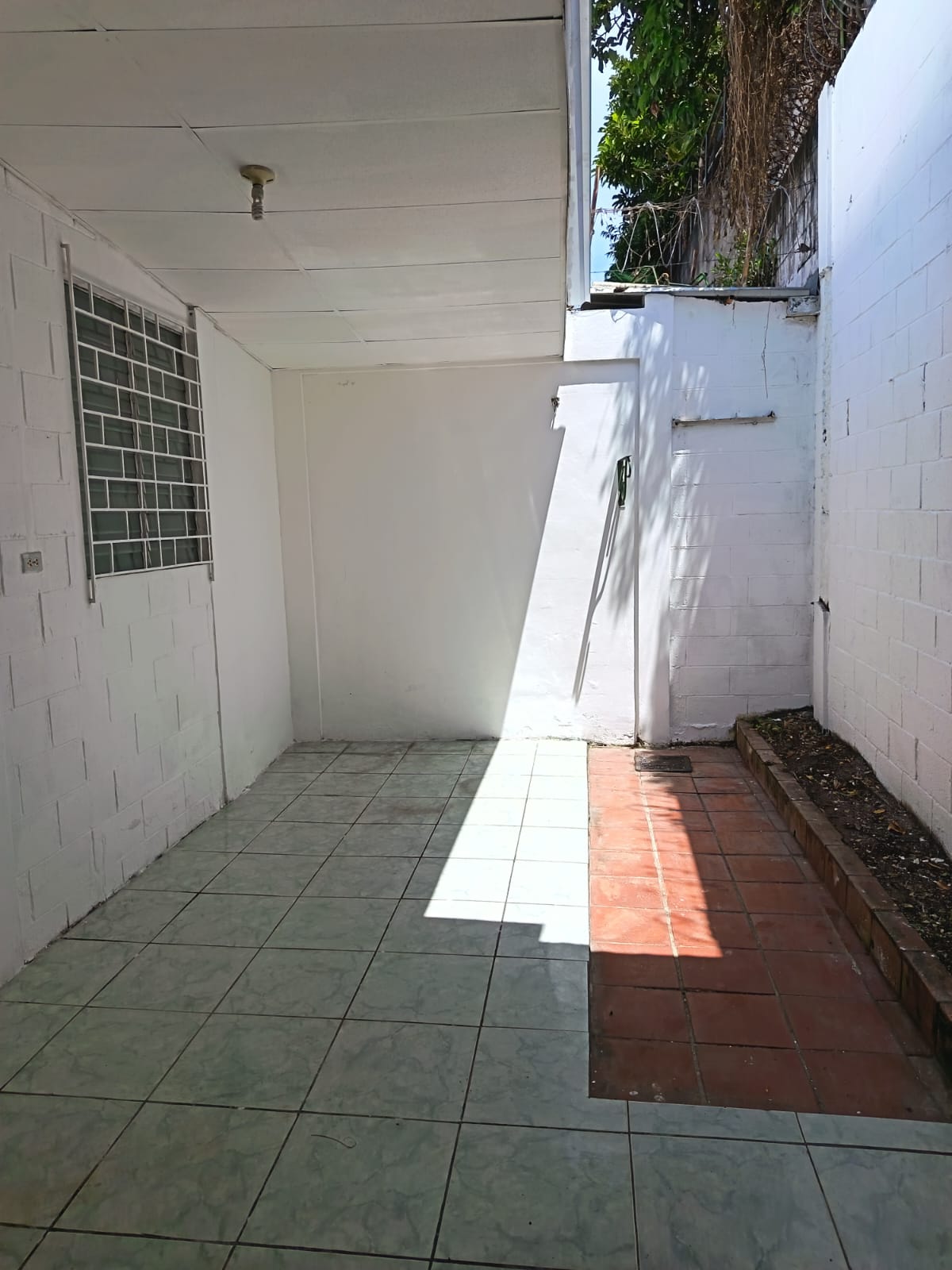 Patio trasero con espacio para un pequeño jardin e iluminacion tanto natural como artificial