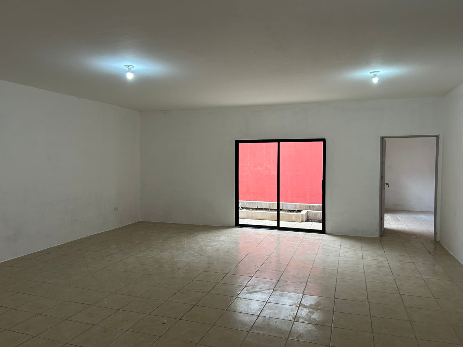 Salon principal con piso ceramico y salida a patio trasero