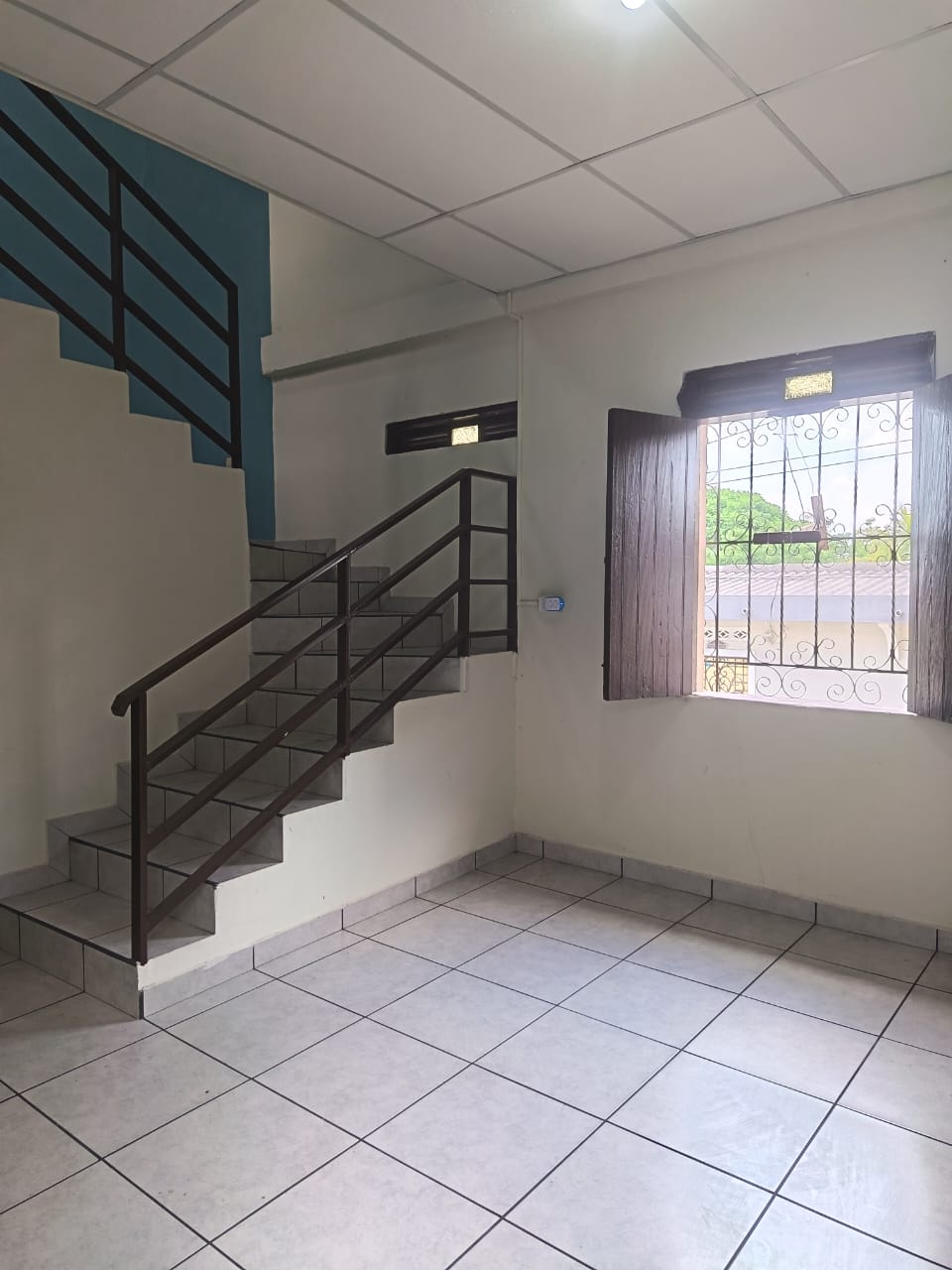 Escaleras interiores con pasa mano y ventana tradicional de madera
