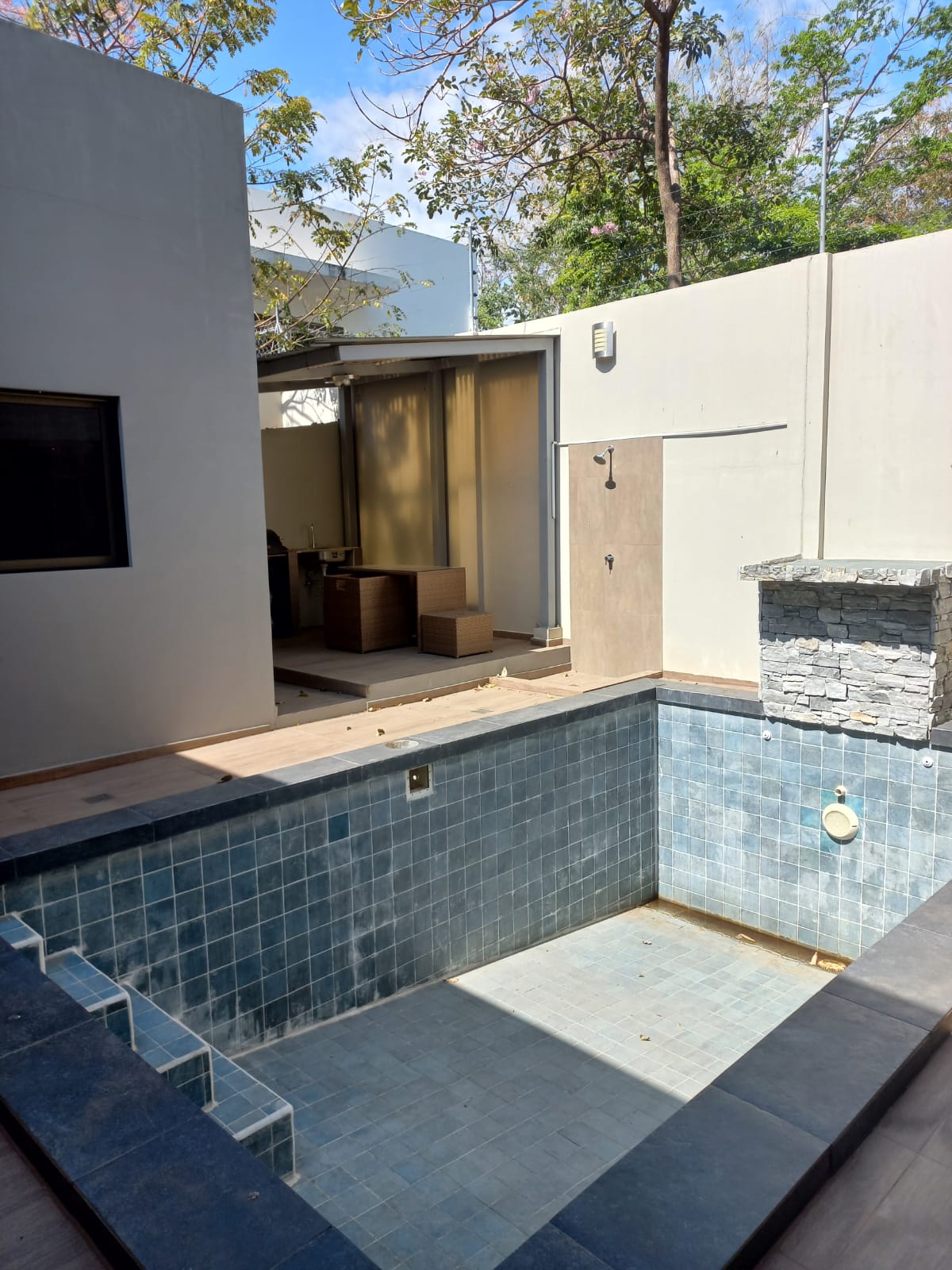 Piscina vacia, piso ceramico y ducha