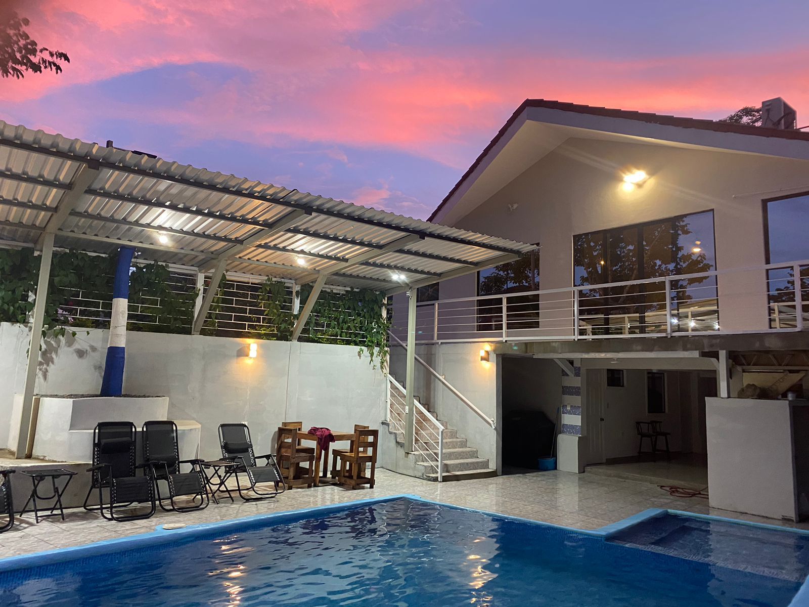 Parte trasera de la casa con piscina y espacio para descansar