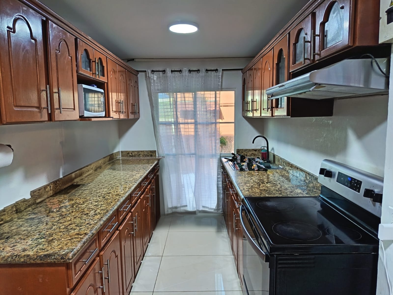 Cocina completamente amueblada con ventana francesa hacia patio trasero