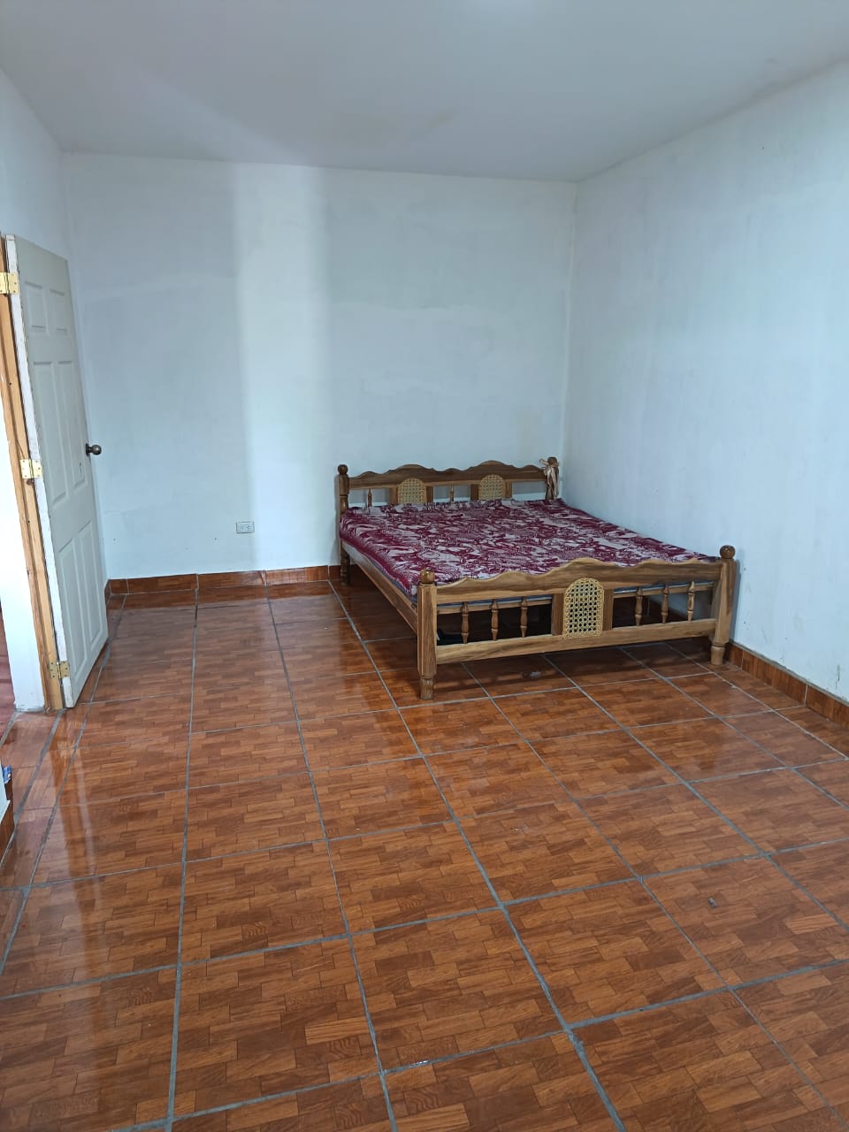 Habitacion con cama de madera y piso ceramico