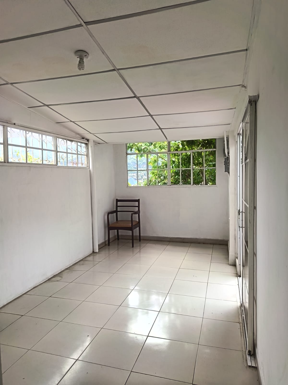Amplia habitación con ventanas francesas y puerta hacia patio trasero