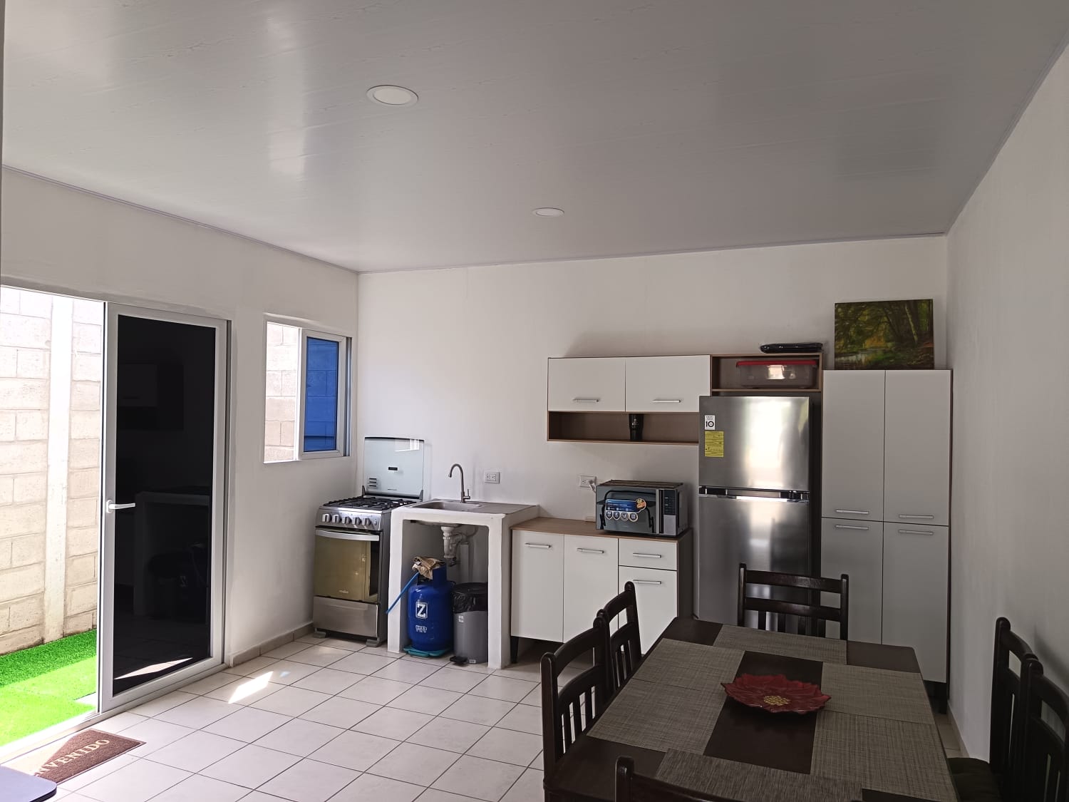 Cocina, lavamanos refrigeradora, pantry y comedor con salida al patio