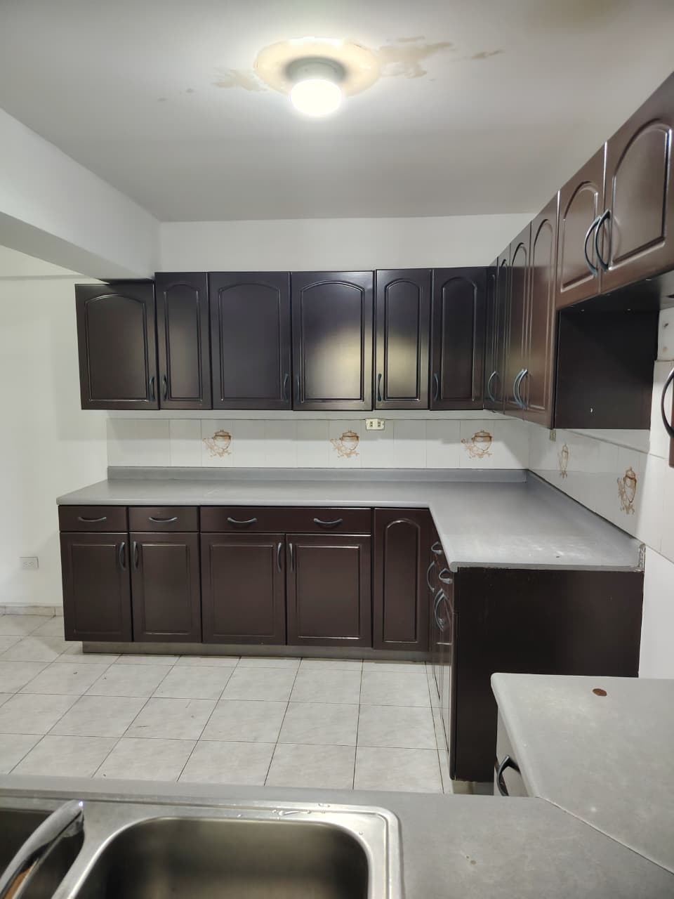 Cocina espaciosa con respectivo lavamanos y pantry muy bien disribuido