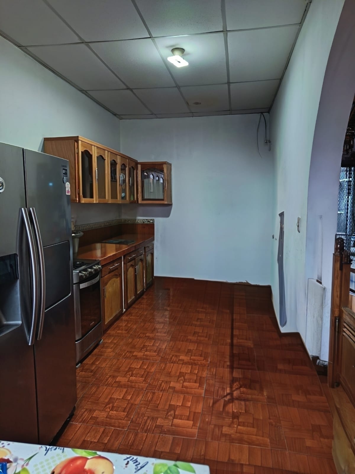 Cocina amueblada con refrigerador plateado y gabinetes de madera