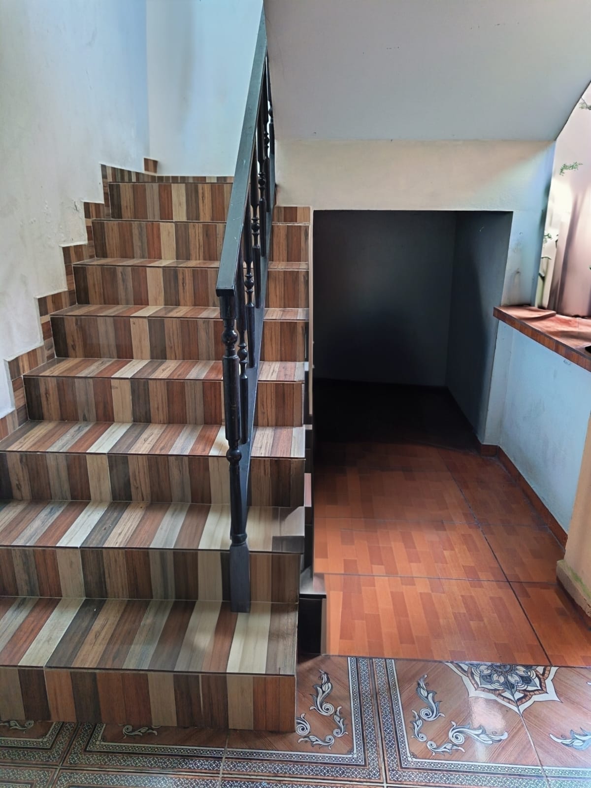 Escaleras interiores con cerámica multicolor y barandales negros