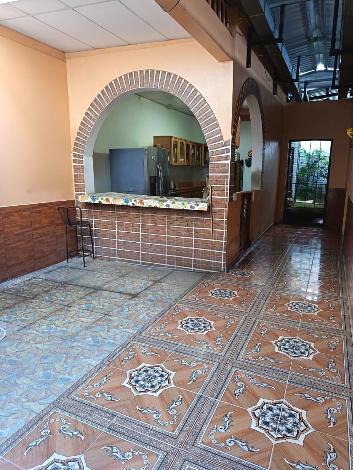 Bar con estructura de ladrillo arqueado y cocina trasera