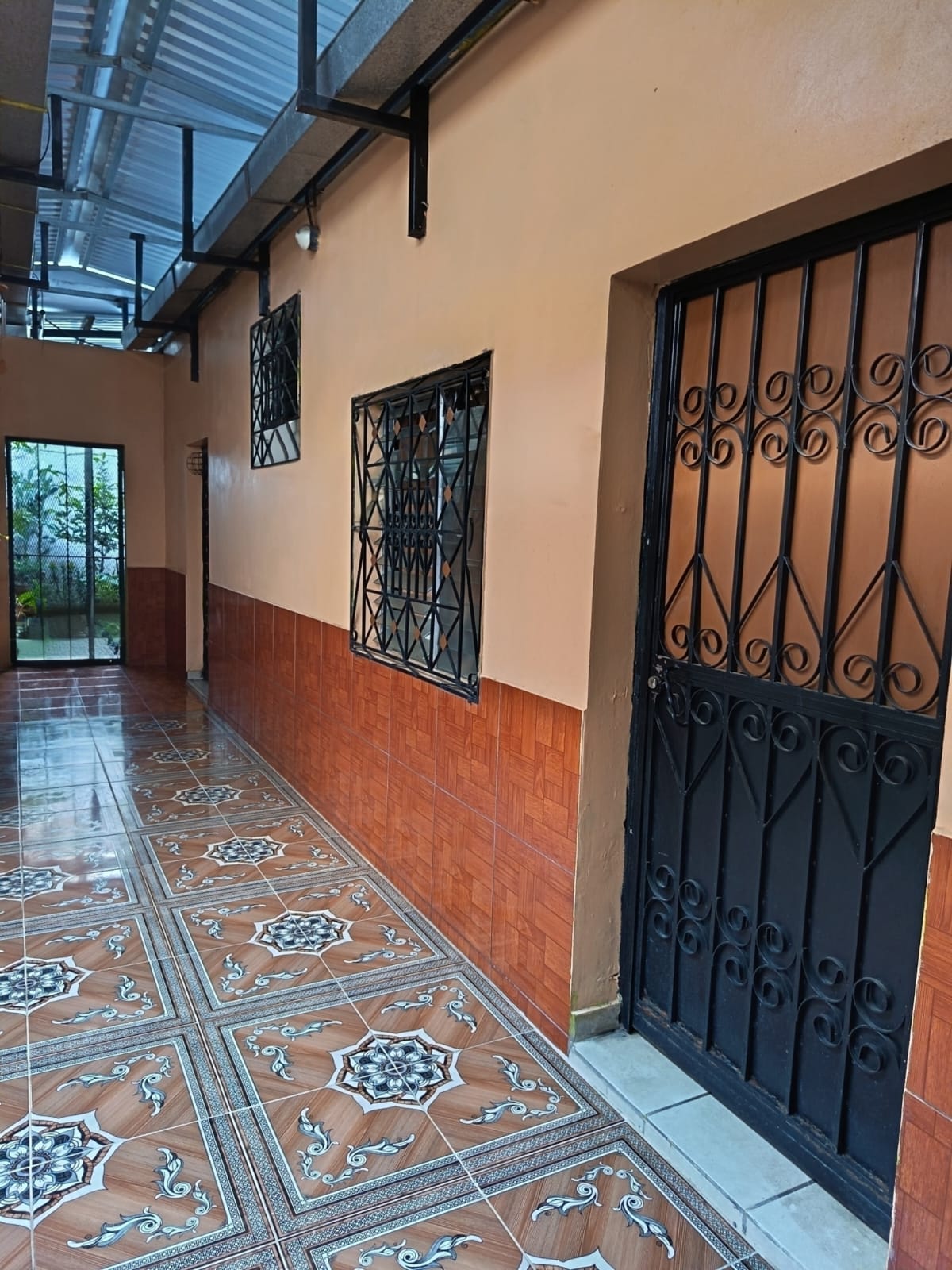 Corredor interior con puertas de hierro forjado y luz natural