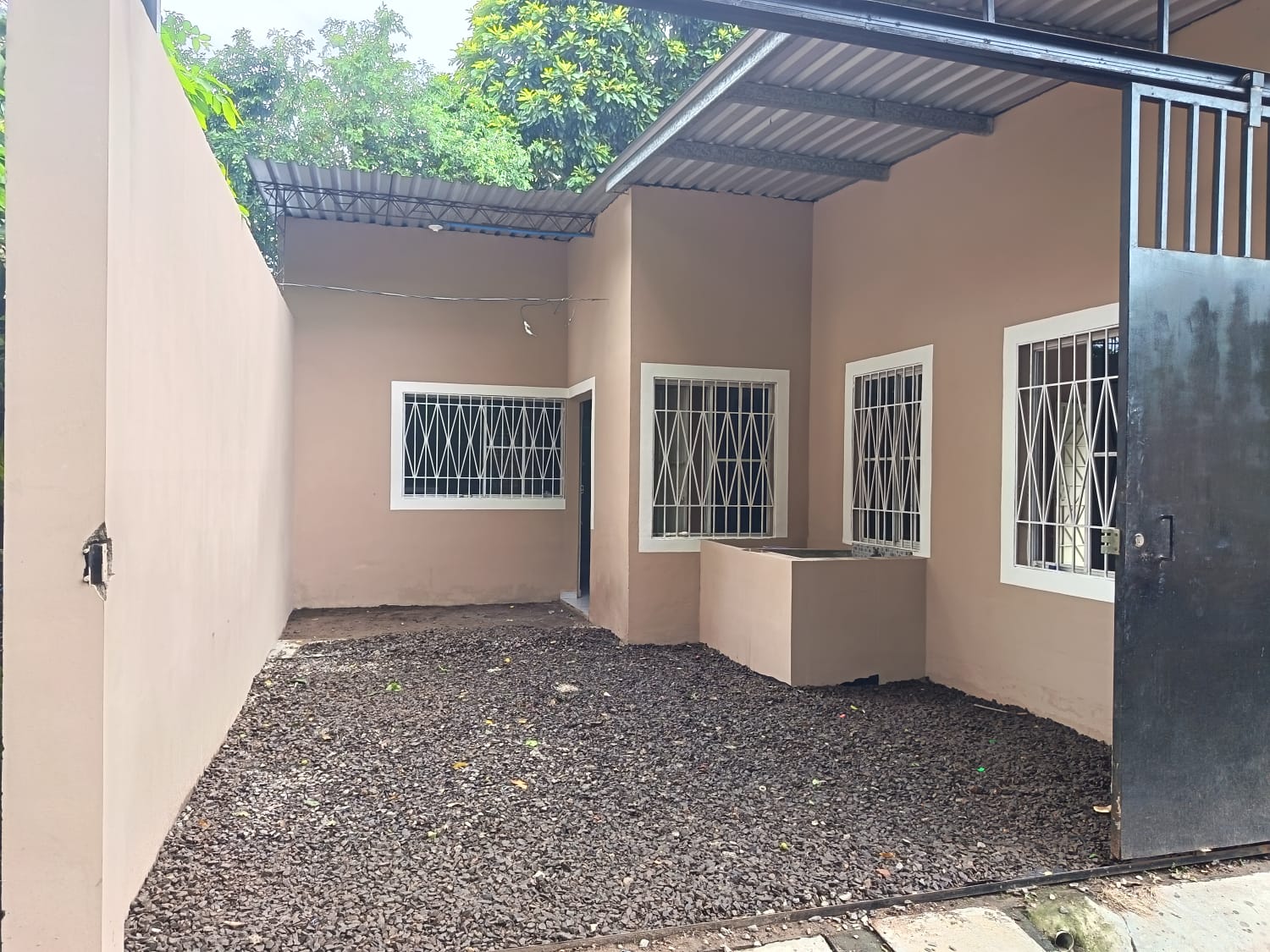 Cochera con grava, lavadero y entrada secundaria a propiedad