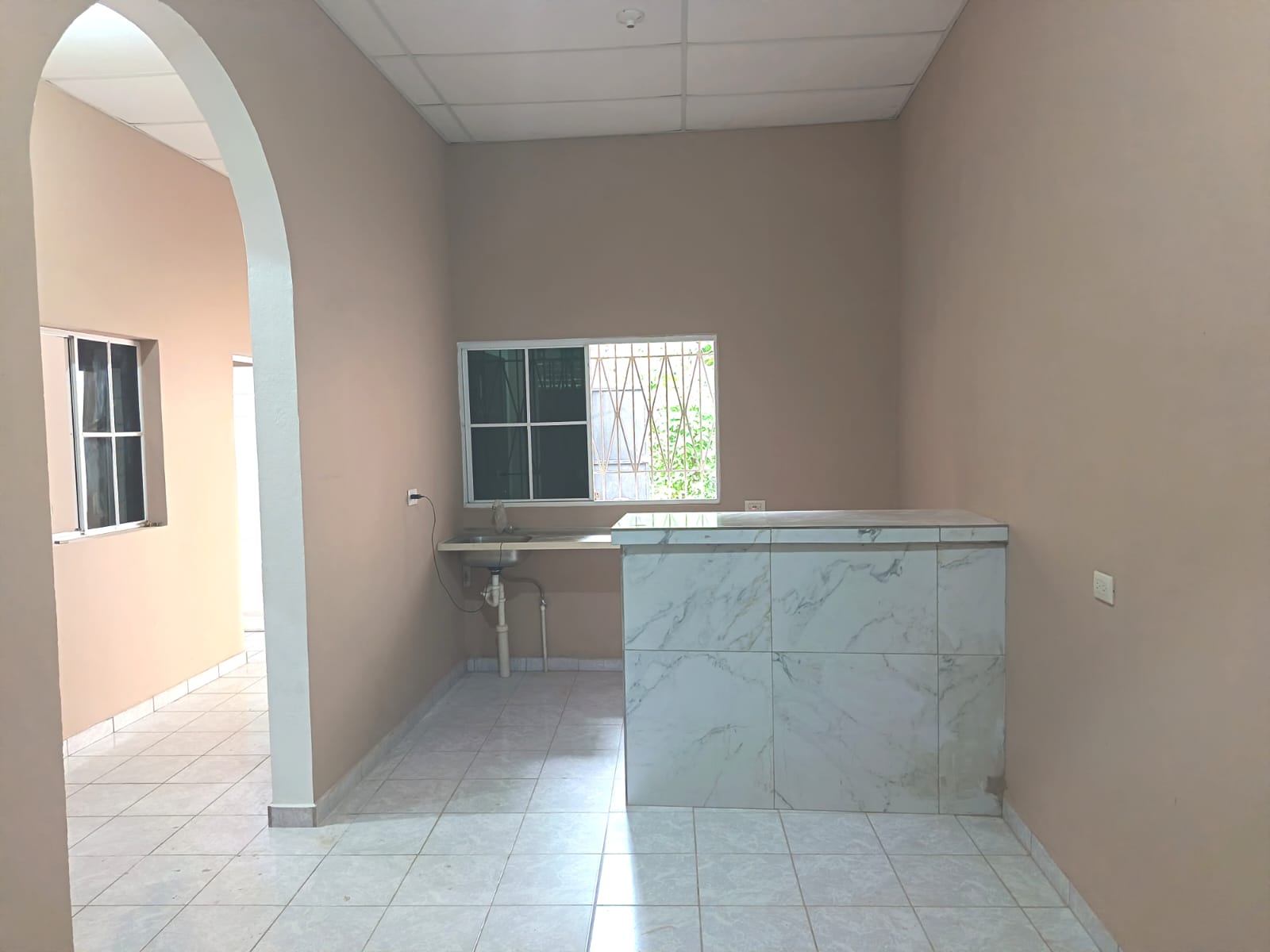 Desayunador ceramico con lavamanos y ventana con vista a patio trasero